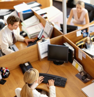 high angle view of a businessman and two businesswomen working in an office --- Image by © Royalty-Free/Corbis